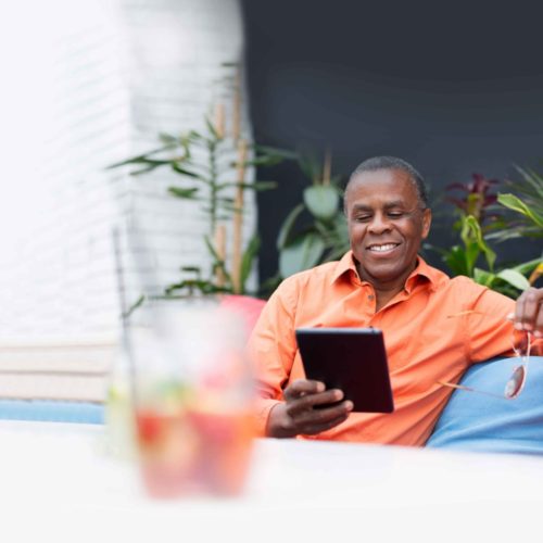 Relaxed man on ipad, generating income with options